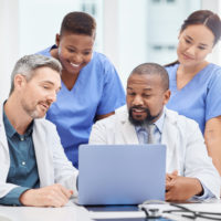 A group of medical professionals on a laptop.