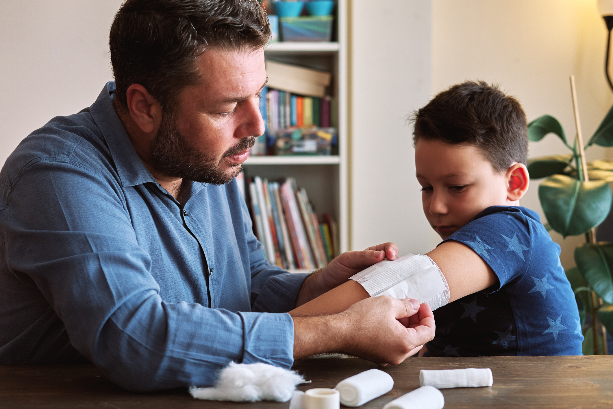 Father performing first aid on child, not sure if he needs stitches