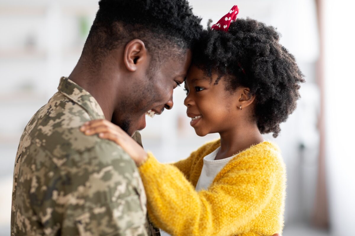 Happy African American soldier reunited with his daughter